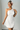 Female wearing a White Solid Color Bodycan Asymmetric Neckline Dress