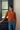 Female wearing a Rust Solid Color Fusion V-Neck Neckline Shawl Collar Top